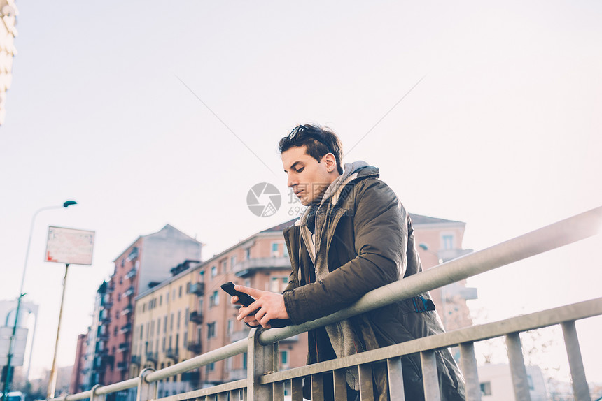 使用智能手机靠扶的男人图片