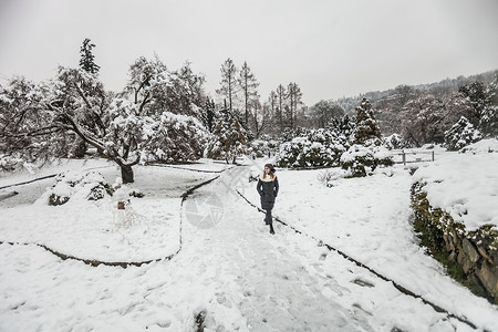 妇女走在雪覆盖的风景上图片