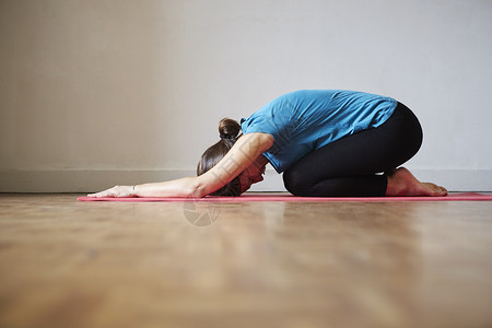 女人的侧面弯腰手放在地板上瑜伽姿势图片
