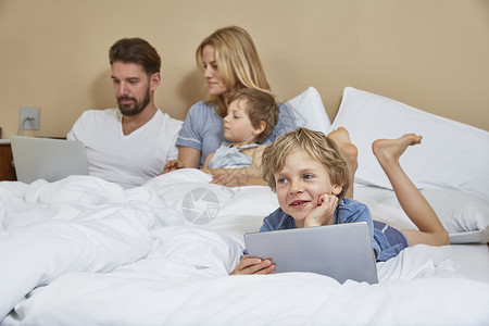 母亲和父使用技术与儿子同床睡觉图片