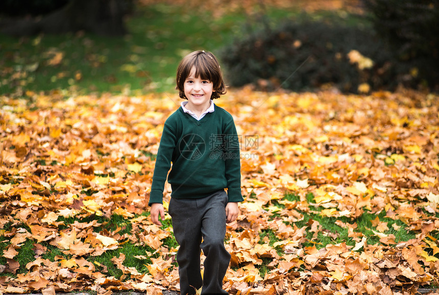 秋天在公园的男孩看着镜头微笑图片
