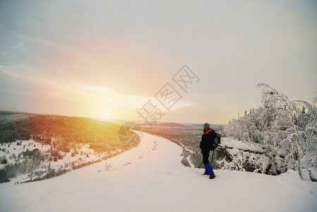 人类在雪上覆盖着风景看冰冻河流的日落风景图片