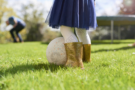 穿着金色靴子玩球的女孩图片