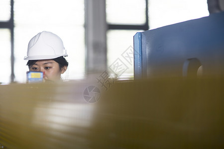 女技术员检查工厂的测量仪图片