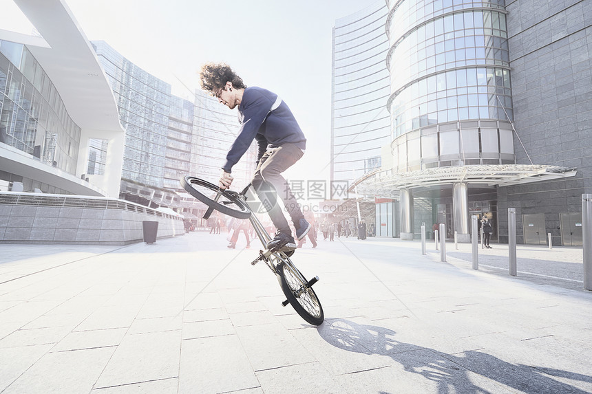 在城市里使用自行车做特技的青年男性图片