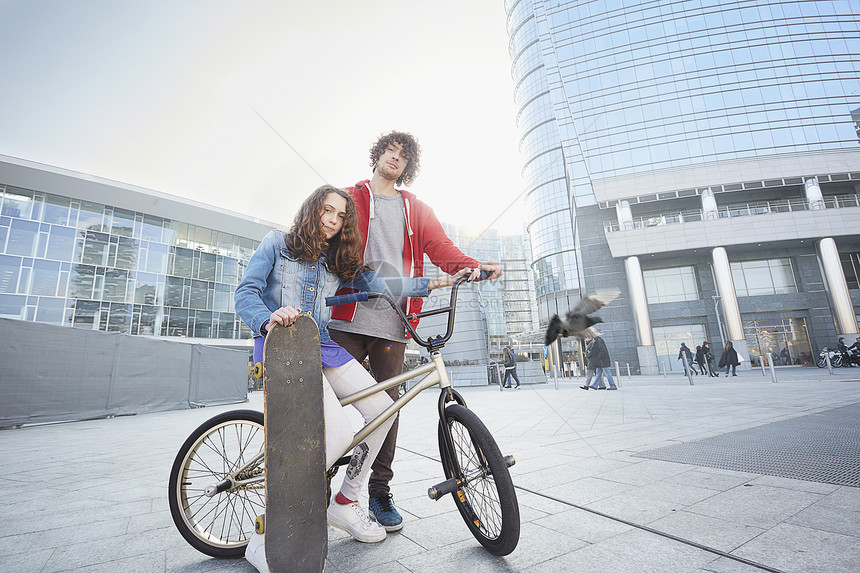 骑自行车的男人和玩滑板的女人图片