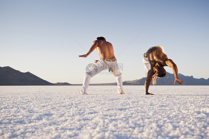 美国犹他州博纳维尔盐滩上两名男子表演杂技图片