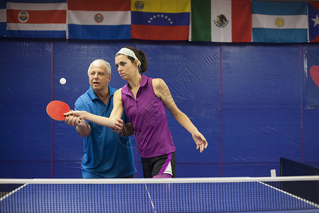 男教练教女子打乒乓球图片