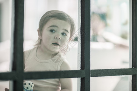 婴儿女孩透过窗户看图片