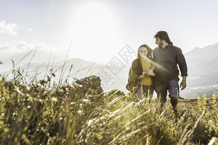 在草原上散步的一对情侣高清图片