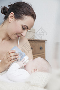 亲用奶瓶喂婴儿喝奶高清图片