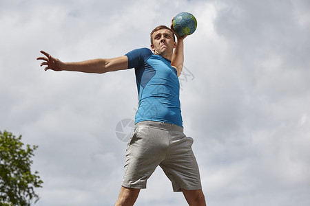 年轻男手球员准备灌篮的仰拍视角图片