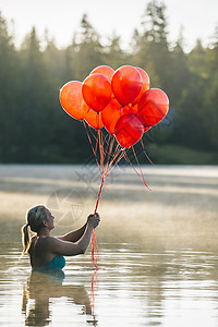 水中女人拿着一堆红色气球图片