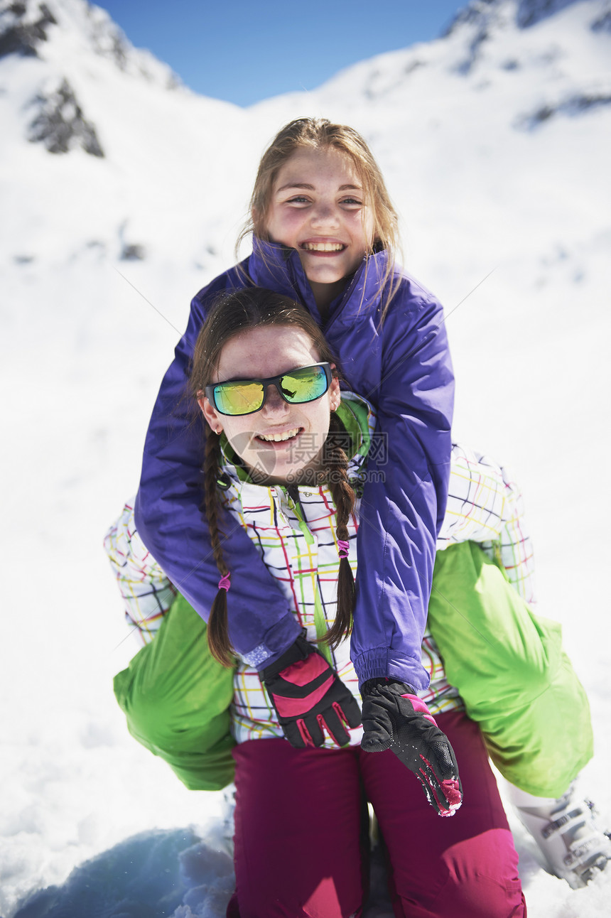 雪地中穿着滑雪服的姐妹图片
