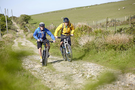 在泥土上骑自行车的运动员图片