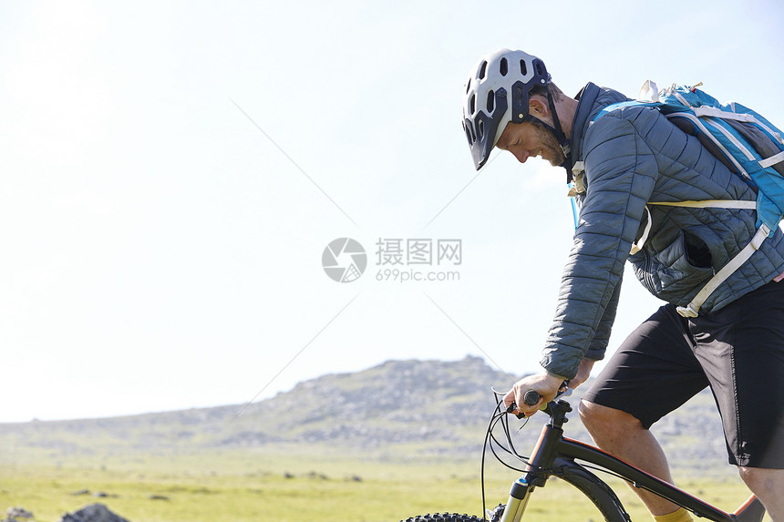 在山坡骑自行车的侧视图图片