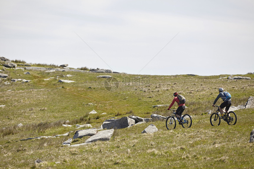 在岩石山坡上骑自行车的运动员图片