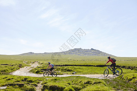 在山坡路上骑自行车的运动员图片