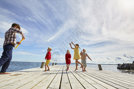 一群小朋友在木码头上玩耍图片
