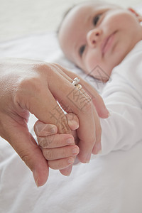 男婴握着母亲的手指图片