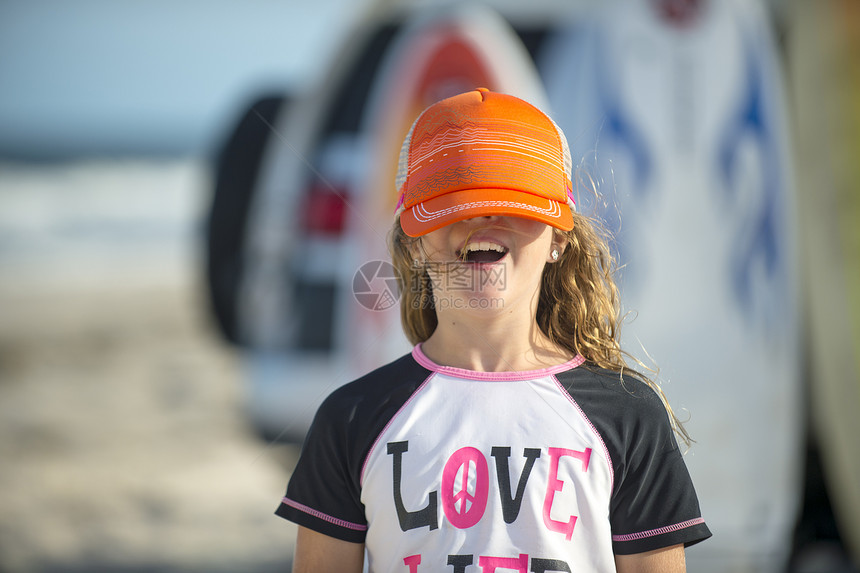 海滩上年轻女孩用帽子遮着眼睛图片