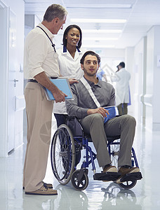 医生咨询坐在轮椅上手臂受伤的病人图片
