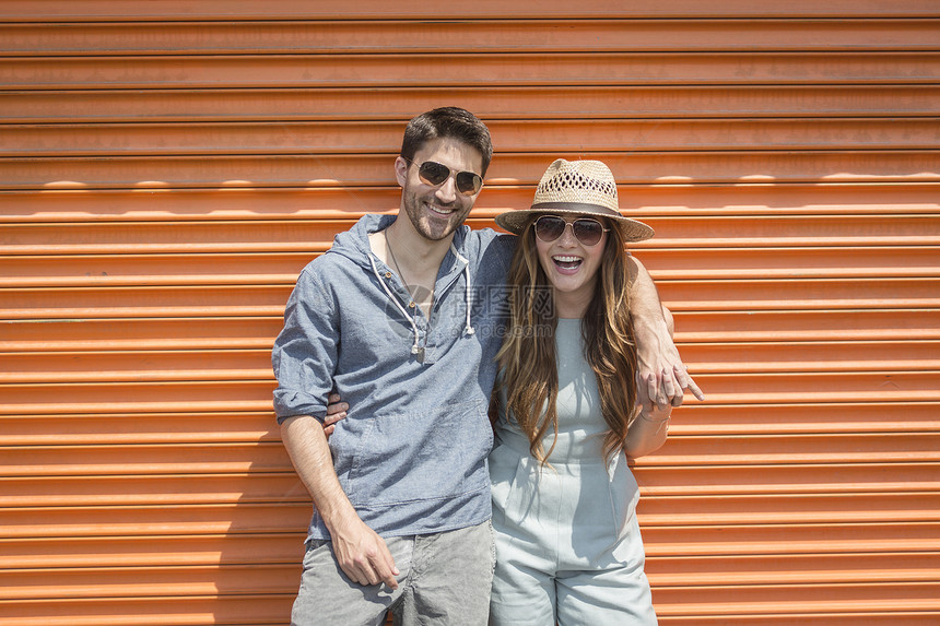 美国纽约布鲁克林科尼岛内一对夫妇靠在橙色车库前看摄像机图片