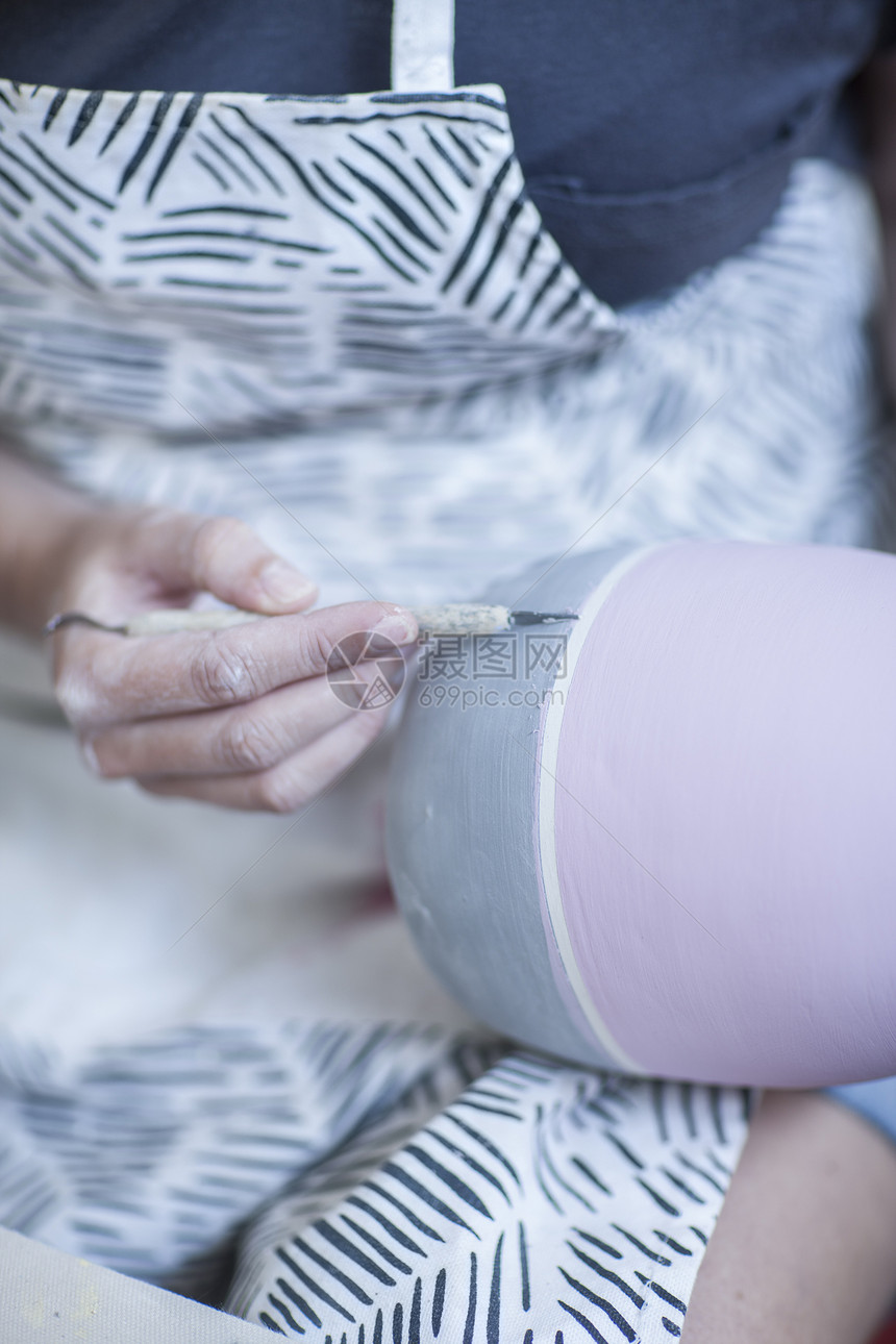 女陶艺师在陶器上雕刻花纹图片