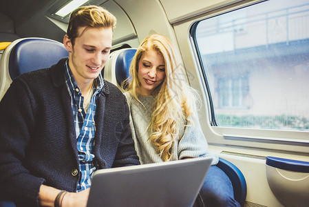 意大利小夫妇在乘火车旅行时用电脑打字图片