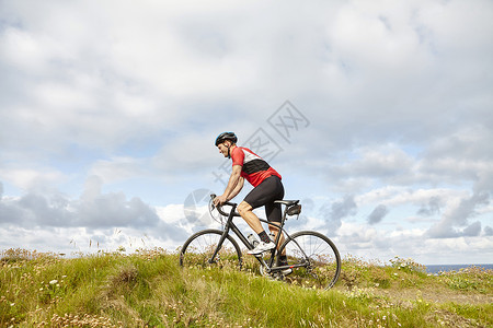 骑过草地的自行车运动员图片