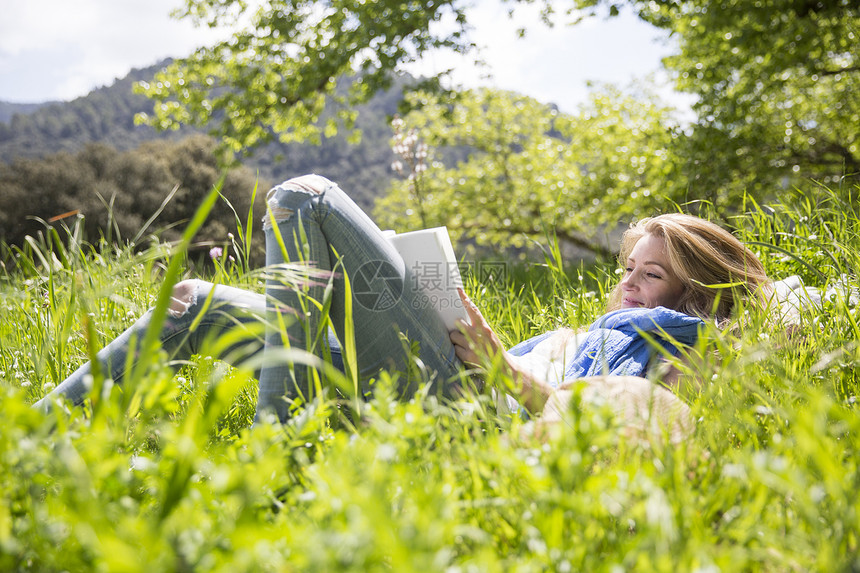 女人躺在草地上读书图片