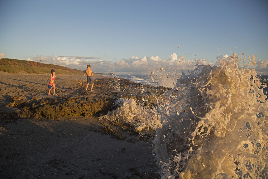 美国佛罗里达州日出时在海滩上玩耍的小男孩和小女孩图片