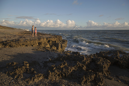 男孩和姐妹观看海浪美国佛罗里达州木星布洛岩保护区图片