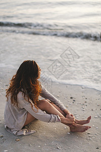 坐在海滩上的女性图片