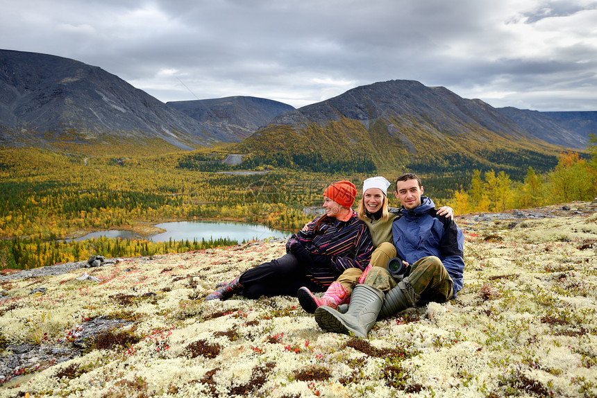 俄罗斯科拉半岛希比尼山脉三名年轻徒步旅行者坐在一起微笑图片
