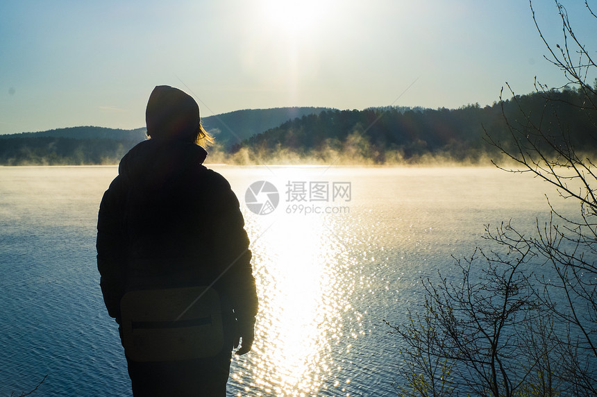 日落时在湖边观光的旅游者图片