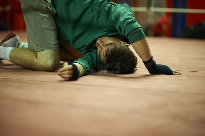 年轻男子在拳击体育馆锻炼伸展图片