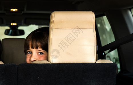 从车后座向后看的男孩图片