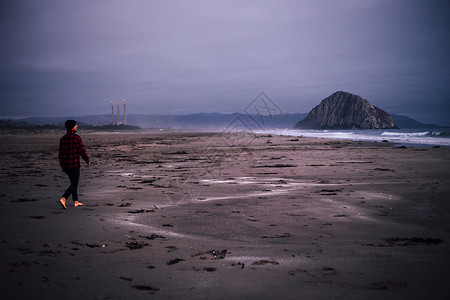 光脚徒步在海滩上行走的成年男性背景图片