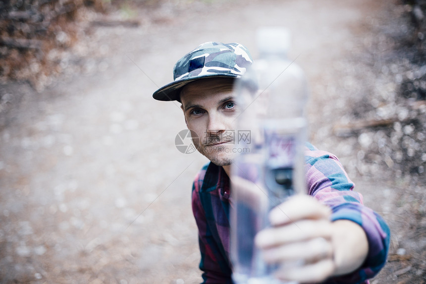 在户外持有水瓶的男人肖像图片