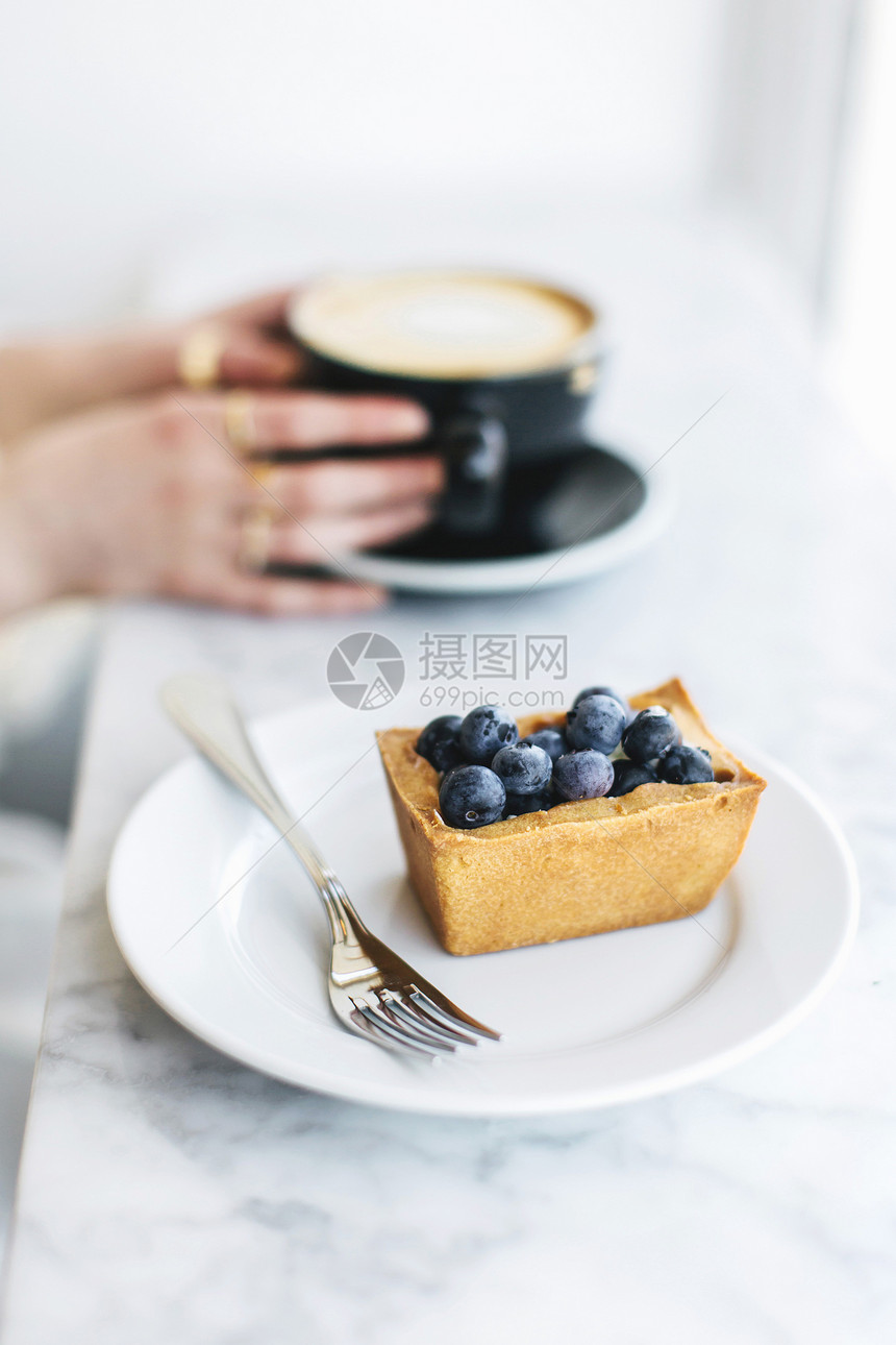 水果塔和手握着冷冻咖啡的女子手图片