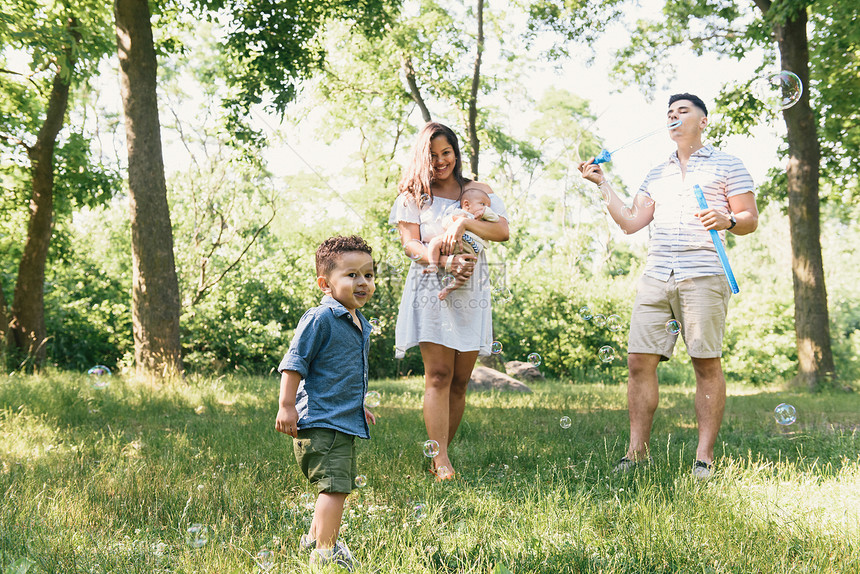 美国纽约布朗克斯PelhamBay公园的家长们与幼童和小儿子一起吹泡图片