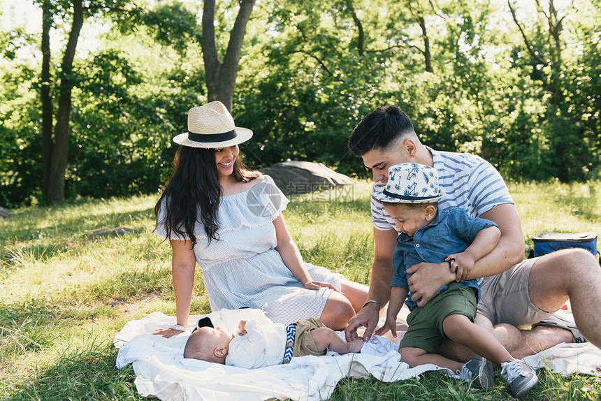 美国纽约布朗克斯PelhamBay公园的野餐毯上看着小儿子的家长和幼图片