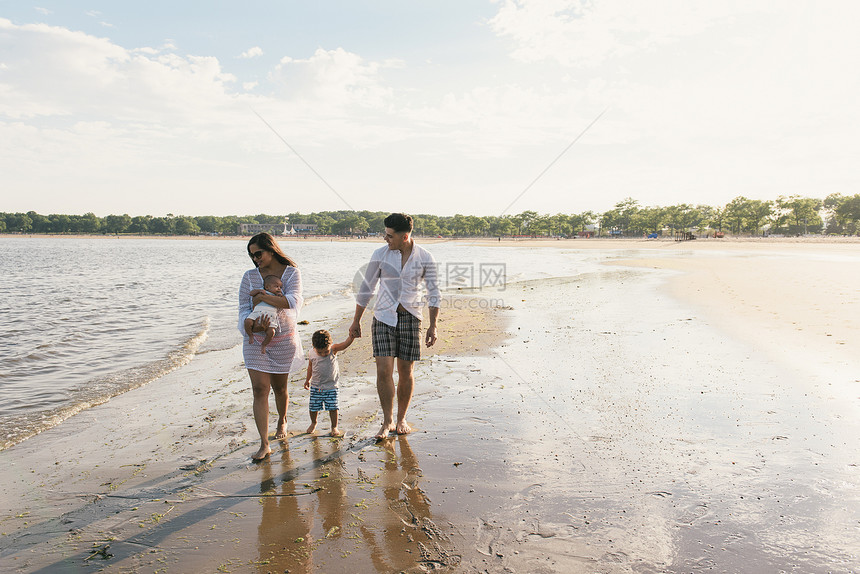 父母在美国纽约布朗克斯PelhamBay公园海滩上与幼儿和婴一起散步图片
