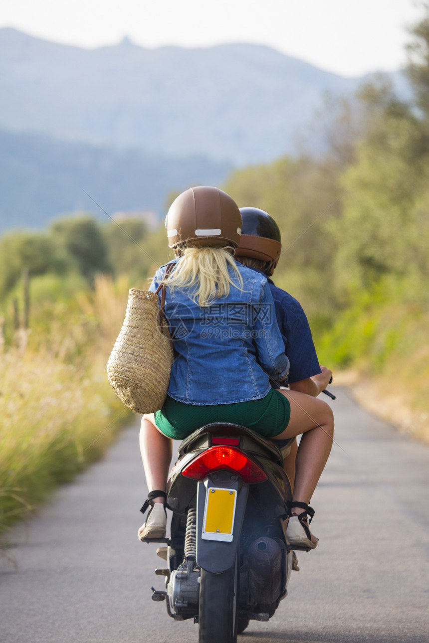 在西班牙马雅卡的农村公路上骑脚踏摩托车的年轻夫妇近视西班牙马杰卡图片