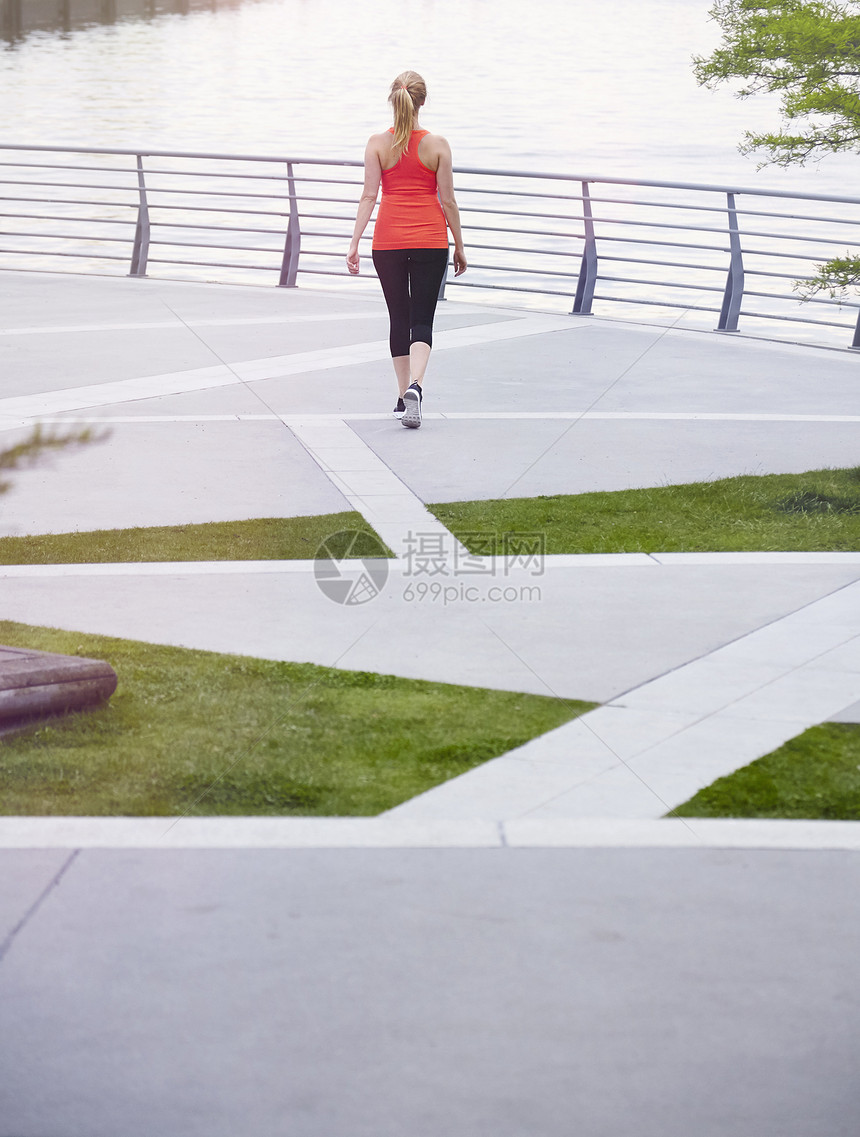 妇女穿着运动服在城市风景地带运动图片