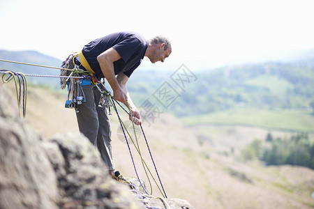 攀岩者拿着爬绳往下看图片