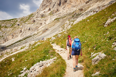 奥地利山路上背着背包的徒步旅行者图片