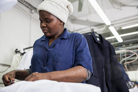 服装厂熨烫衣服的工人忙碌的高清图片素材