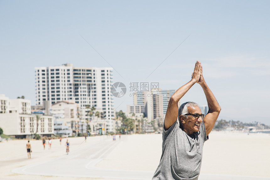 年长男子在海滩上练习瑜伽姿势美国加利福尼亚州长滩图片